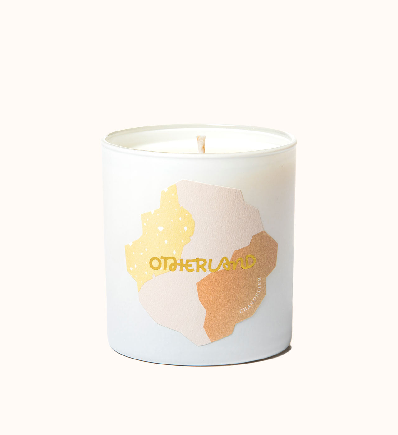 Candle with 'Otherland' branding on a white background