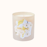 Candle with floral design and 'Otherworld' branding on a white background