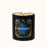 Black candle with 'Otherland' branding and celestial design on a white background