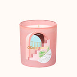 Pink candle with a decorative label on a white background